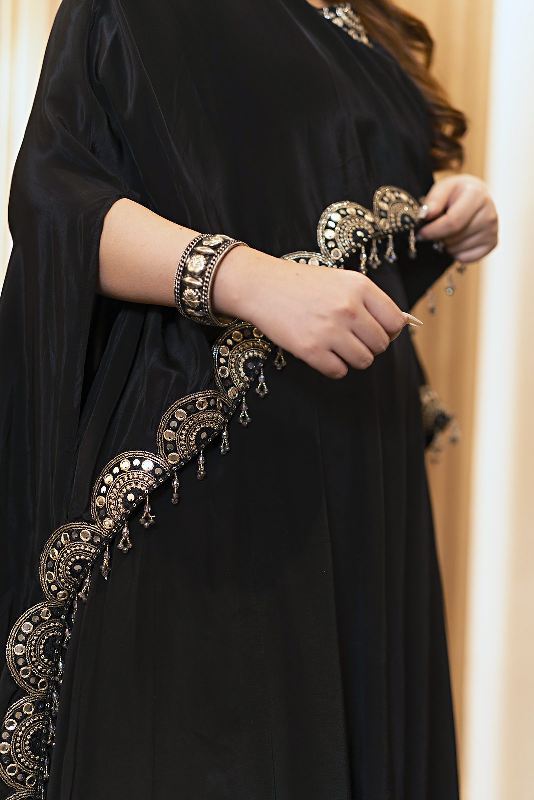 D lace and moti fringe along the cape edge, close-up