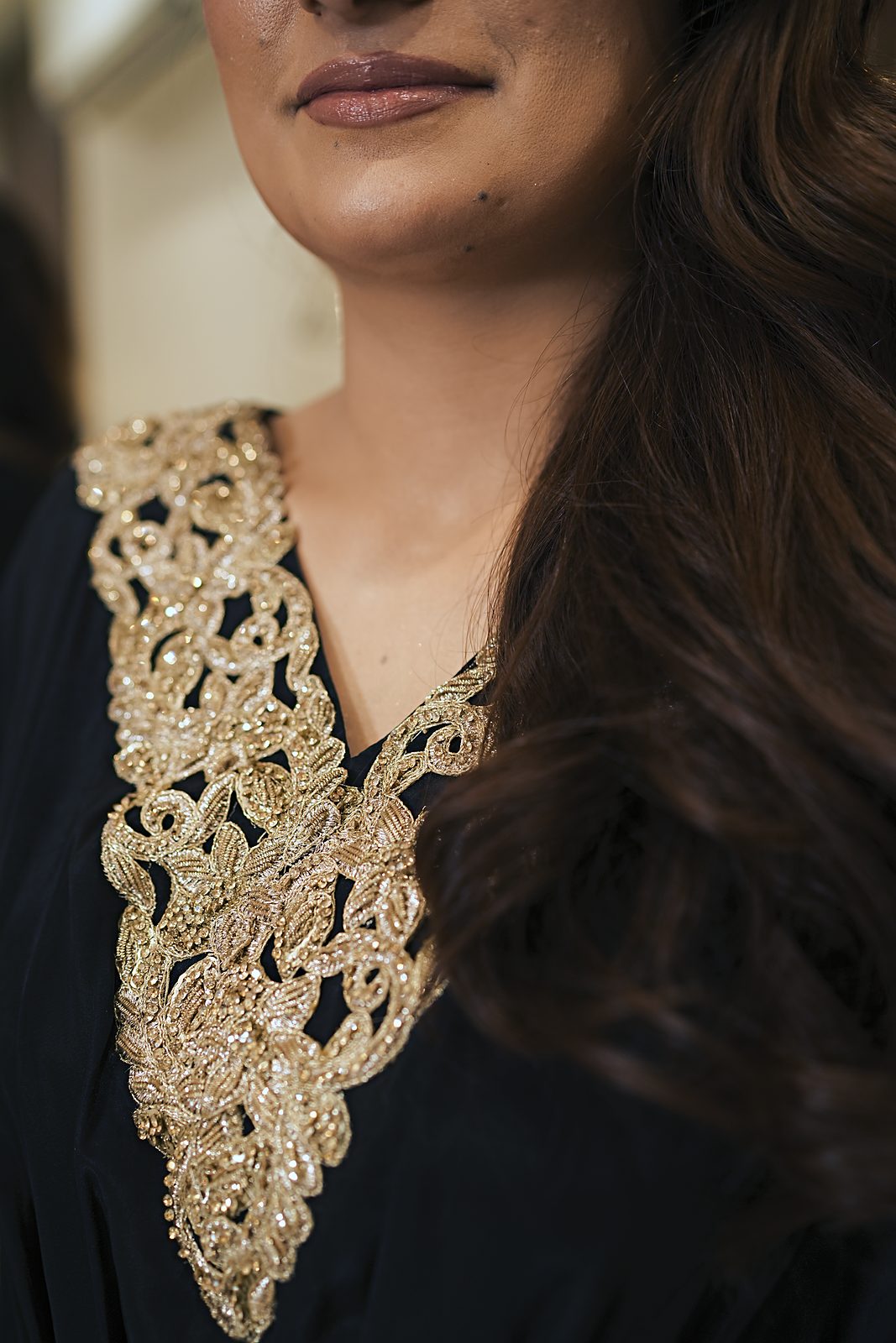Detail of the handmade gold lace V-neckline